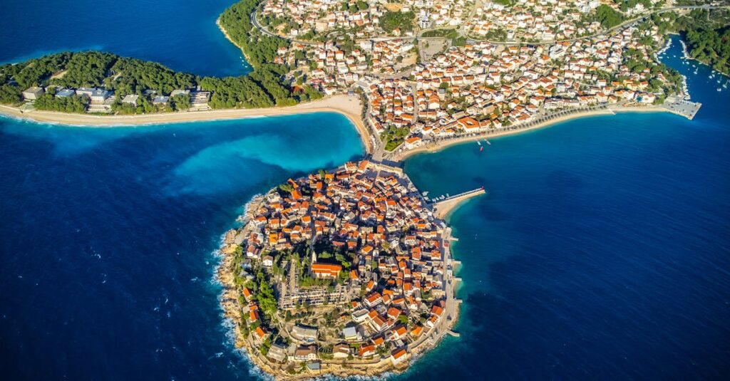 Stunning aerial view of Primošten peninsula in Croatia surrounded by clear blue waters.